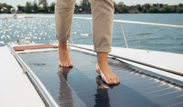 Person walking across a BougeRV CIGS flexible solar panel installed on a boat