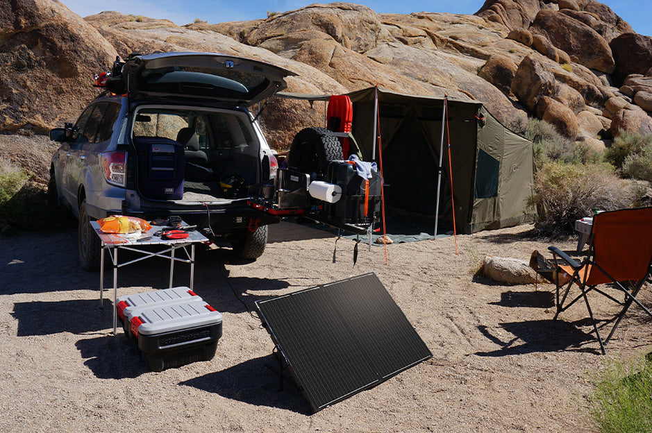 Renogy portable solar suitcase charging at an outdoor campsite
